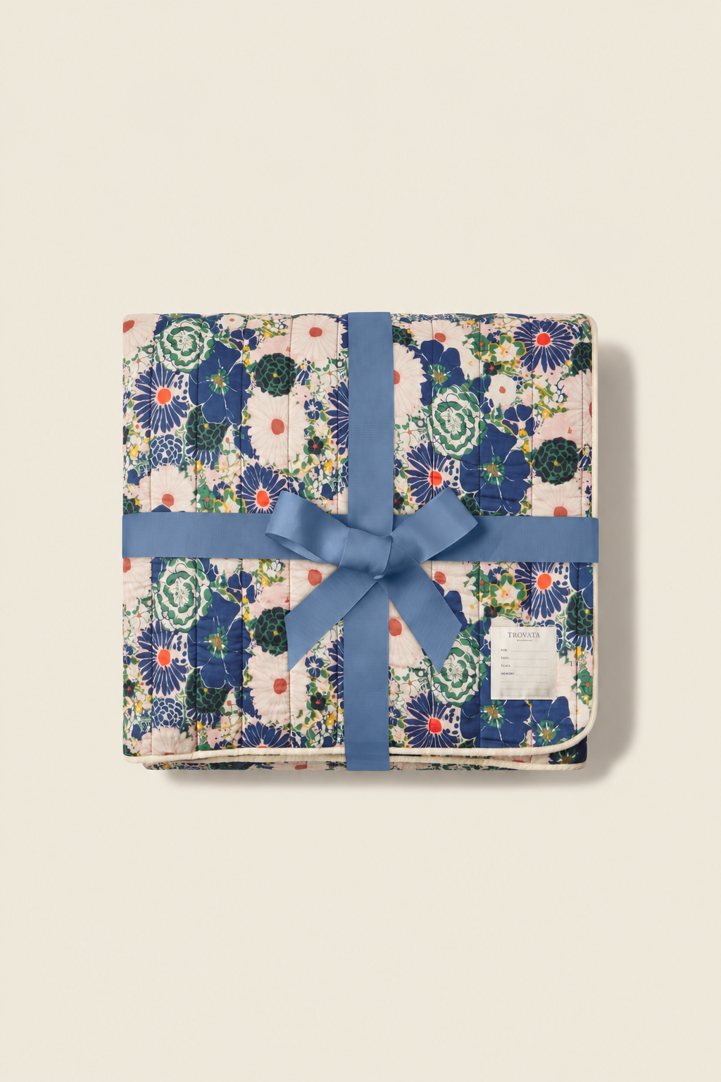Trovata Medley printed throw blanket — folded and tied with a blue ribbon bow